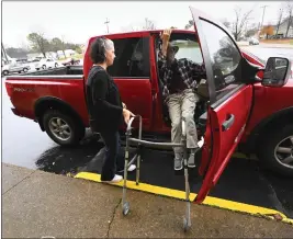  ?? ?? Jerry Lamb, who suffers from a spine condition, gets out of his truck while his wife, Laura, waits to assist him as they arrive at Camden First United Methodist Church in Camden, Tenn., on Dec. 8.