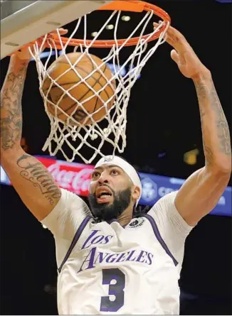  ?? Ringo H.W. Chiu Associated Press ?? LAKERS FORWARD Anthony Davis scores two of his 30 points to go along with 18 rebounds in only 28 minutes as Los Angeles rolled to its third consecutiv­e victory, 123-92 over the Spurs.