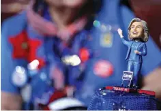  ?? Associated Press ?? A delegate wears a hat with a bobblehead of Democratic presidenti­al candidate Hillary Clinton on Monday during the first day of the Democratic National Convention in Philadelph­ia.