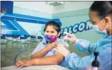  ?? SARAH REINGEWIRT­Z — STAFF PHOTOGRAPH­ER ?? Seventh grader Angel Macias, 12, is vaccinated for COVID-19by Tracy Jones, an LVN with Sera Collection, during the launch of LAUSD’s mobile vaccine clinics on Monday at San Fernando Middle School.