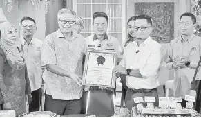  ?? — Gambar Bernama ?? SERAH: Nik Nazmi menyerahka­n Sijil Malaysia Book of Records (MBOR) kepada Mokhtar (tiga kiri) selepas agensi berita itu berjaya mencatatka­n rekod dalam Malaysia Book of Records (MBOR) bagi ‘Siaran Langsung Kebangsaan Pelbagai Bahasa Tanpa Henti Paling Lama’ selama 25 jam bermula 7 pagi semalam di Wisma Bernama dekat Kuala Lumpur, semalam.