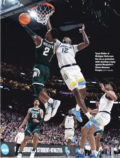  ?? GETTY IMAGES ?? Tyson Walker of Michigan State uses the rim as protection while shooting a layup against Marquette’s Olivier-Maxence Prosper.