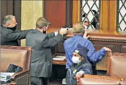  ??  ?? Tense: Capitol security forces watch as protesters attempt to break in.