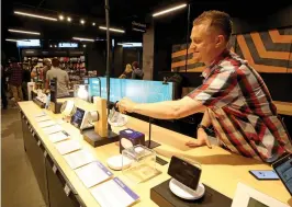  ?? Greg Gilbert/The Seattle Times/TNS ?? ■ Jacob Evans, assistant store manager at Amazon’s Seattle 4-star store, organizes a display of Alexa products. Amazon is opening its sixth 4-star store in Frisco, Texas this week.
