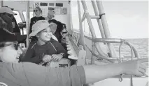  ?? ALIE SKOWRONSKI Miami Herald/TNS ?? University of Miami student Emily Yeager, left, points out a landmark to Neela Barberouss­e, 12, during a shark tagging expedition.