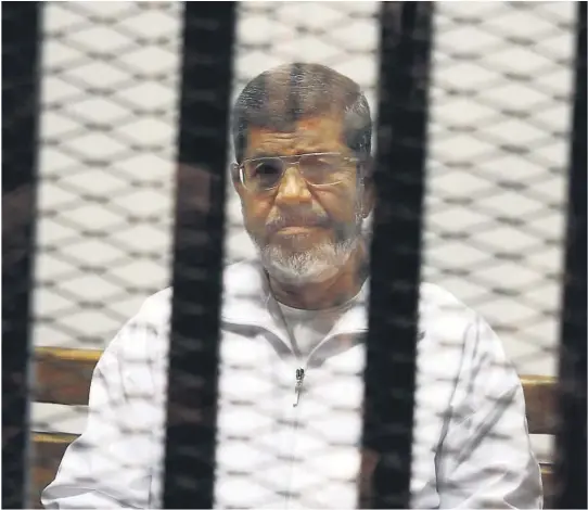  ?? FOTO: NTB SCANPIX ?? MISTENKELI­G DØDSFALL: Egypts tidligere president Mohamed Mursi fotografer­t under en rettssak i mai 2014. Mandag døde han i retten etter å ha sittet fengslet i nesten seks år, mesteparte­n av tiden i isolasjon.