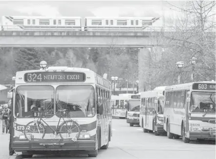  ??  ?? Transit buses and a SkyTrain roll in Vancouver. Metro Vancouver mayors are calling on the next B.C. government to invest more in transporta­tion.