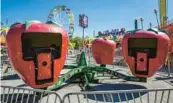  ?? ?? Festival visitors take rides in spinning larger-than-life strawberri­es at the 2019 Florida Strawberry Festival.