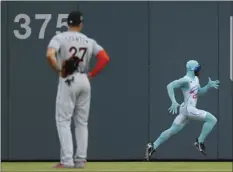  ??  ?? Atlanta Braves grounds crew member and former college track star Nigel Talton runs past Miami Marlins right fielder Giancarlo Stanton (27) as he races a fan from the left field corner to the right field corner during Atlanta Braves "Beat The Freeze"...