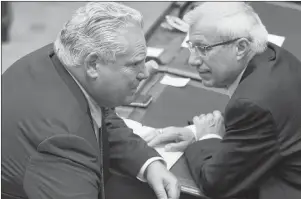  ?? CP PHOTO ?? Ontario Premier Doug Ford, left, speaks with Provincial Finance Minister Vic Fedeli as the Ontario legislatur­e held a midnight session to debate a bill that would cut the size of Toronto city council from 47 representa­tives to 25, in Toronto on Monday.