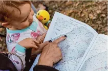  ?? ?? Hunt and Ember look at “Road Atlas for the Total Solar Eclipse of 2024” at their camp. Eclipse-seekers came to the park hoping for four minutes of totality during the eclipse.