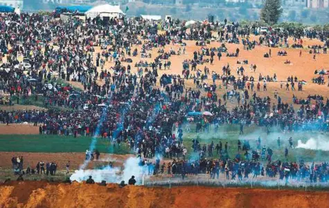  ?? Reuters ?? ■ Israeli occupation soldiers fire tear gas at Palestinia­ns during the Land Day demonstrat­ion on the Gaza border yesterday.