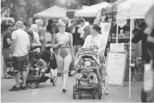  ?? DAX MELMER ?? Shoppers peruse the produce and goods for sale by a variety of vendors along the stretch of Pelissier Street on Saturday.