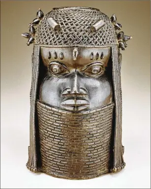  ?? FRANKO KHOURY/NATIONAL MUSEUM OF AFRICAN ART ?? A metalwork head of a king is in the Benin Kingdom Court Style from the 18th century. The Smithsonia­n replaced looted pieces with photos and an explanator­y sign.