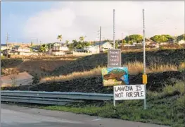  ?? Lindsey Wasson Associated Press ?? SIGNS reading “Respect locals” and “Lahaina is not for sale” are seen in the Maui city in December. Last summer’s deadly wildfire destroyed over 2,000 homes.