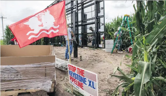  ?? NATI HARNIK/AP ?? The Cowboy Indian Alliance flag, representi­ng a group of ranchers, farmers and tribal communitie­s opposing the Keystone XL pipeline, flies in a cornfield along the path of the proposed project that has been beset with opposition. TransCanad­a says the...