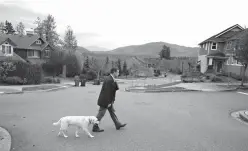  ?? Associated Press ?? ■ Sen. Mark Mullet, D-Issaquah, walks Monday with his dog Arthur as he rings doorbells of registered voters in Issaquah, Wash. Mullet is being challenged for his seat in the state Legislatur­e by state Rep. Chad Magendanz, R-Issaquah.