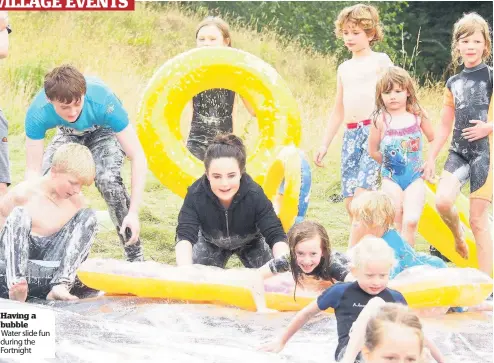  ??  ?? Having a bubble Water slide fun during the Fortnight