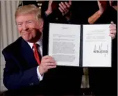  ?? KEVIN LAMARQUE / REUTERS ?? US President Donald Trump displays a presidenti­al public health emergency declaratio­n on the nation's opioid crisis in the East Room of of the White House in Washington on Thursday.