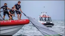  ??  ?? Team New Zealand crewmen grab the sail of the United States’ American Magic’s boat, Patriot, after it capsized during its race against Italy’s Luna Rossa on the third day of racing of the America’s Cup challenger series on Auckland’s Waitemate Harbour, New Zealand on Sunday. (AP/NZ Herald/Michael Craig)