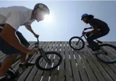  ??  ?? C.R. Shepherd, left, and Cole Nielsen ride the wall at Sunnyside Bike Park.