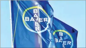  ?? PATRIK STOLLARZ/AFP ?? The logo of German chemicals giant Bayer is seen on flags during the company’s annual results press conference in Leverkusen on February 28.