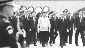  ??  ?? Duterte (centre) visits the National Cemetery in Seoul. — AFP photo