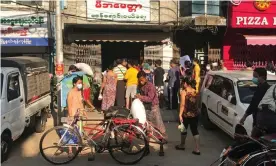  ?? Photograph: Reuters ?? People queue up outside a grocery store in Yangon.