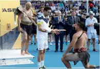  ?? AFP ?? Roberto Bautista Agut (centre) receives a traditiona­l spear from a Maori warrior after winning the Auckland Classic title. —