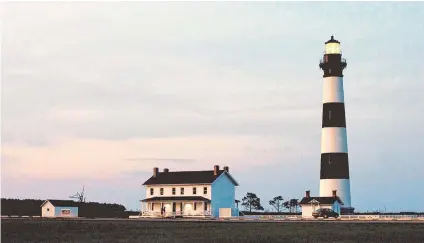  ?? ROBERT WILLETT rwillett@newsobserv­er.com ?? The Bodie Island Lighthouse is illuminate­d as dusk falls on at the Cape Hatteras National Seashore on the outer banks of North Carolina in 2015.