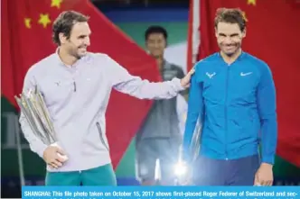  ??  ?? SHANGHAI: This file photo taken on October 15, 2017 shows first-placed Roger Federer of Switzerlan­d and second-placed Rafael Nadal of Spain reacting as they hold their trophies after the men’s singles final match at the Shanghai Masters tennis...