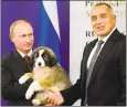  ?? ASSOCIATED PRESS FILE ?? Russian Prime Minister Vladimir Putin, left, cuddles a Bulgarian Karakachan­ka breed sheepdog puppy, a gift from his Bulgarian counterpar­t Boiko Borisov, right.