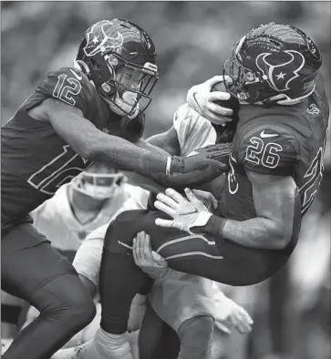  ?? Matt Patterson Associated Press ?? THE TEXANS’ Royce Freeman (26) gets a shove from Nico Collins near the goal line. Said former tackle Andrew Whitworth of push plays, “It’s a symbolizin­g play of the day, kind of the mentality of your O-line.”