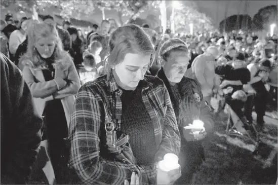  ?? Michael Owen Baker For The Times ?? BRIANNA MICHAUD, left, and her mother, Cherylynn Michaud, pray at a vigil. The shooting marks the third Whittier officer to be killed in the line of duty.