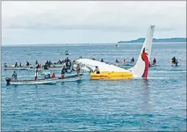  ?? JAMES YAINGELUO/AP ?? Islanders move in to rescue passengers and crew Friday in the Chuuk Island lagoon.