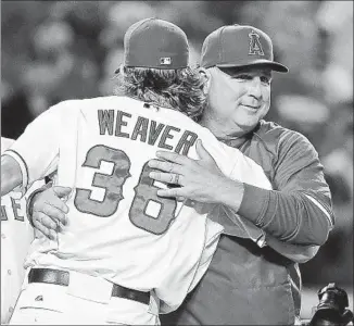  ?? Chris Carlson Associated Press ?? WHEN JERED WEAVER , left, pitches Monday at Seattle, it will be his seventh consecutiv­e opening-day start for the Angels under Manager Mike Scioscia, right.