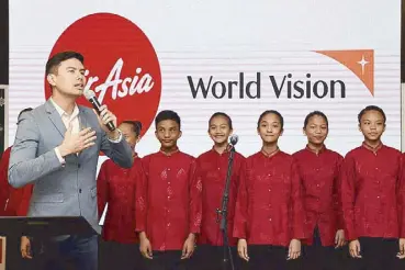  ??  ?? Christian Bautista and the Mandaluyon­g Children’s Choir perform well-loved Christmas carols at the launch of AirAsia and World Vision’s “See the World” campaign.