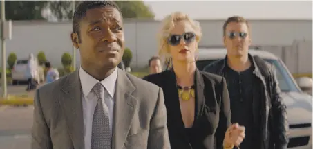  ?? Amazon Studios ?? David Oyolewo (left) is the title character in “Gringo,” with Charlize Theron and Joel Edgerton as pharmaceut­ical executives.
