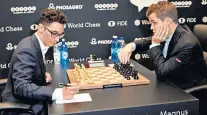  ??  ?? First move: Caruana (left) and Carlsen prepare to play