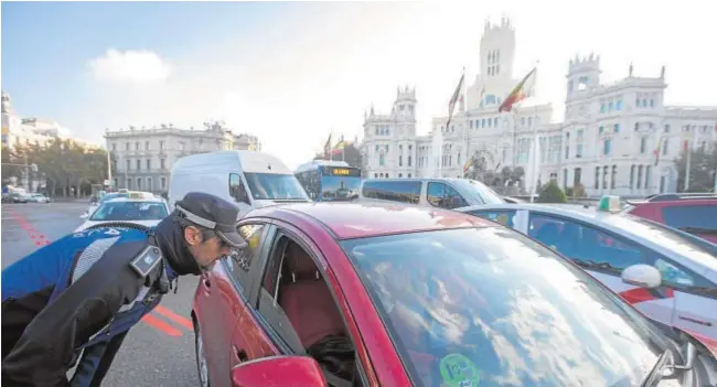  ?? IGNACIO GIL ?? Un policía municipal informa a un conductor sobre las nuevas restriccio­nes de circulació­n