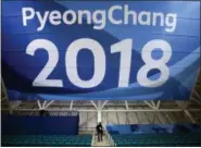  ?? JAE C. HONG - THE ASSOCIAED PRESS ?? FILE - In this Feb. 6, 2018file photo, a photograph­er walks down the steps underneath a large banner at the Gangneung Hockey Center ahead of the 2018Winter Olympics in Gangneung, South Korea.