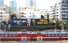  ?? (Ammar Awad/Reuters) ?? POSTERS OF Benny Gantz and Benjamin Netanyahu. Many on the Left have said the probe was timed to harm Gantz before the election.