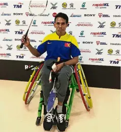  ??  ?? Sporting spirit: Anibal posing with the wheelchair a Malaysian athlete loaned him for his matches.
