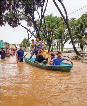  ?? PTI ?? People use a boat to commute in a flooded locality after heavy monsoon rain in Una taluka of Girsomnath district, Gujarat, on Thursday. incessant heavy downpour continued in Gujarat’s saurashtra region, taking the death toll in the state to 32. —