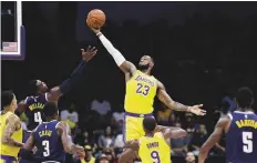  ?? AP ?? Los Angeles Lakers forward LeBron James (23) grabs a rebound over Denver Nuggets forward Paul Millsap (4).