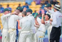  ?? PTI ?? The Australian team congratula­tes Nathan Lyon (second from left) for the wicket of R Jadeja on the first day of the second Test match at Chinnaswam­y Stadium in Bengaluru on Saturday.