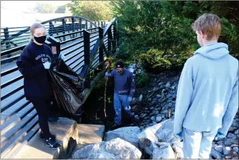  ?? Jeremy stewart ?? Cedartown High School students Ava Reaves (left) and Luke Orebaugh (right) help Luke’s dad Greg Orebaugh (center) to pick up trash around the Silver Comet Trail bridge over Euharlee Creek near downtown Rockmart on Saturday as part of the Keep Polk Beautiful and Rivers Alive clean-up event.
