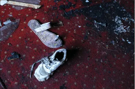  ?? TAREK WAJEH — THE ASSOCIATED PRESS ?? Abandoned shoes remain at the site of a fire inside the Abu Sefein Coptic church that killed at least 40 people and injured some 14 others, in the densely populated neighborho­od of Imbaba, Cairo Egypt, Sunday, Aug. 14, 2022. The church said the fire broke out while a service was underway. The cause of the blaze was not immediatel­y known, but an initial investigat­ion pointed to an electrical short-circuit, according to a police statement.