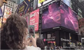  ?? YUKI IWAMURA/AFP VIA GETTY IMAGES ?? Giant screens display images captured by the James Webb Space Telescope in Times Square in 2022 in New York. The telescope afforded researcher­s the opportunit­y to study the chemical compositio­n of a giant gas planet named WASP-107b.