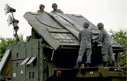 ?? PHOTO: REUTERS ?? Japan Self-Defence Forces soldiers hold a drill to mobilise their Patriot Advanced Capability-3 missile unit in response to recent missiles launch by North Korea.